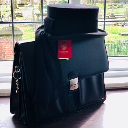 Funeral director's bag and hat waiting on the window sill.